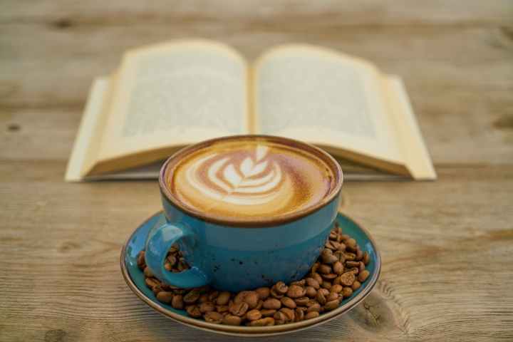 blue ceramic teacup with saucer beside book